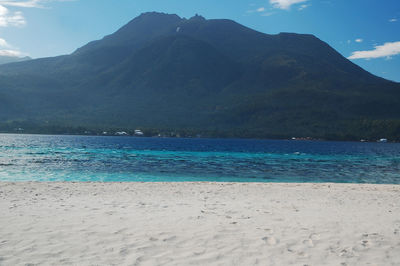 Scenic view of sea and mountains against sky