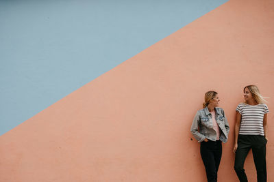 Full length of woman standing against wall