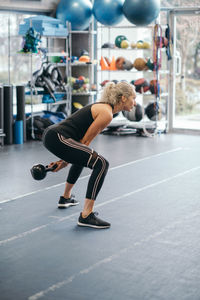 Woman exercising with kettlebell at gym