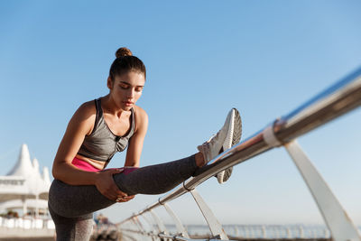 Young woman looking at camera against clear sky