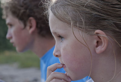 Close-up of siblings looking away outdoors