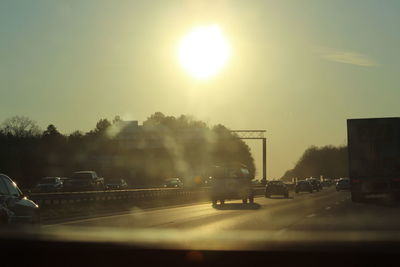 Sun shining through car on road
