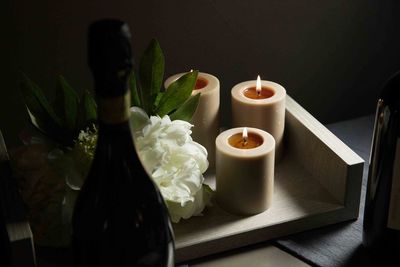 High angle view of lit candles by flower on table