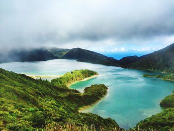 Idyllic view of mountains and river against cloudy sky