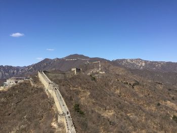 Scenic view of great wall of china and mountains against blue sky