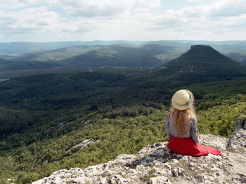 Rear view of man looking at mountains against sky