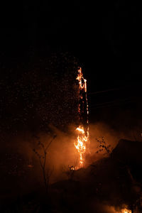 Low angle view of electricity pylon against sky at night