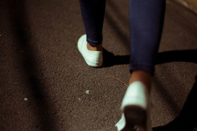 Low section of woman walking on road