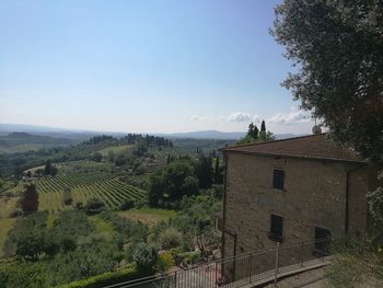 Scenic view of field by buildings against sky