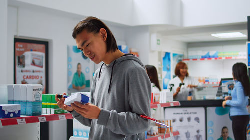 Side view of young woman using digital tablet at home