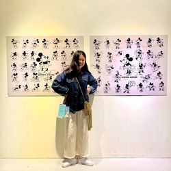 Portrait of young woman standing against wall