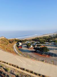 High angle view of road by sea against clear sky
