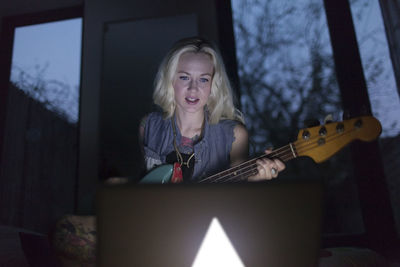 Beautiful young woman playing an electric guitar