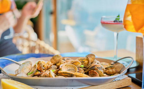 Blurred background with a dish of boiled vongole clams on a table in a cafe with copy space.