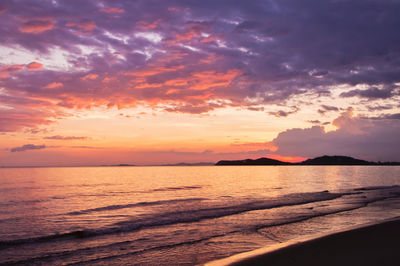 Scenic view of sea against dramatic sky during sunset