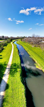 Scenic view of road amidst field against sky