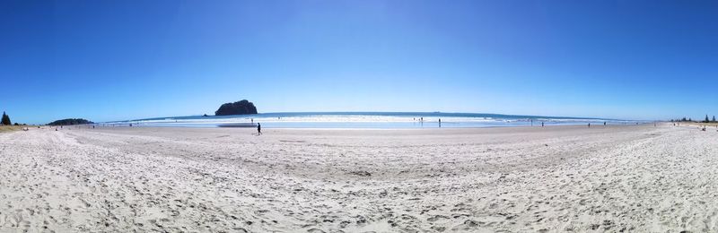 Scenic view of beach against clear blue sky