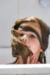 Close-up portrait of playful girl in bathroom