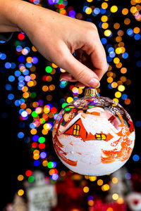 Close-up of hand holding illuminated christmas tree