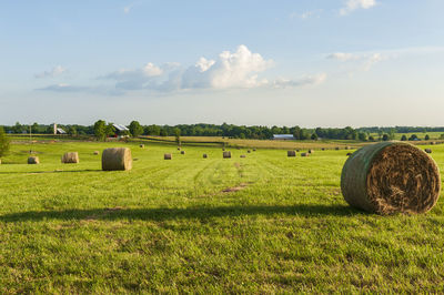 Hay bales on field against sky