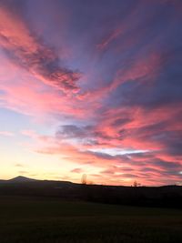 Scenic view of silhouette field against sky during sunset