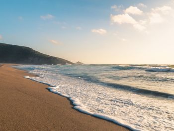 Scenic view of beach against sky during sunset