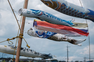 Low angle view of flags hanging against sky