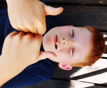 Close-up portrait of boy showing thumbs up