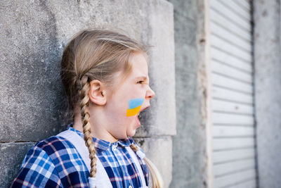 Young woman blowing bubbles against wall