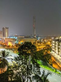 Illuminated buildings in city against sky at night