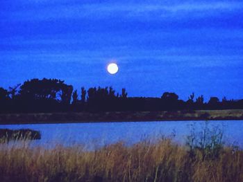 Scenic view of lake against sky at night