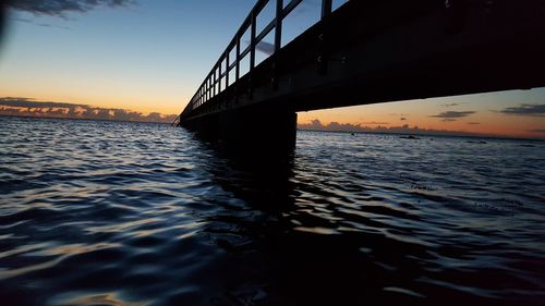 Bridge over river against sky in city