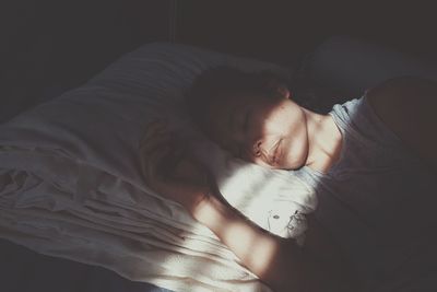 High angle view of woman sleeping on bed