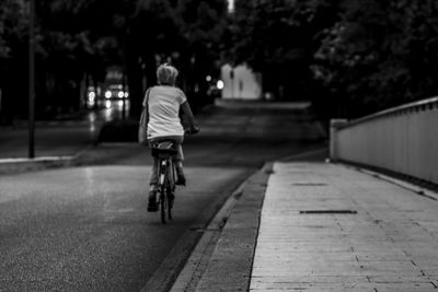 Rear view of boy riding bicycle