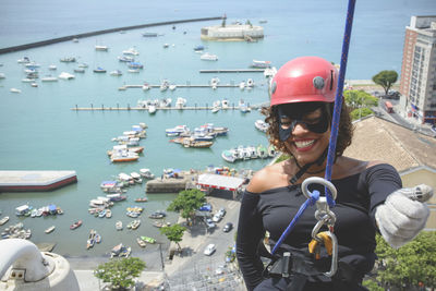 A woman wearing a hero costume with protective helmet walking down a tall rappel building.