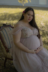 Portrait of young woman sitting on field