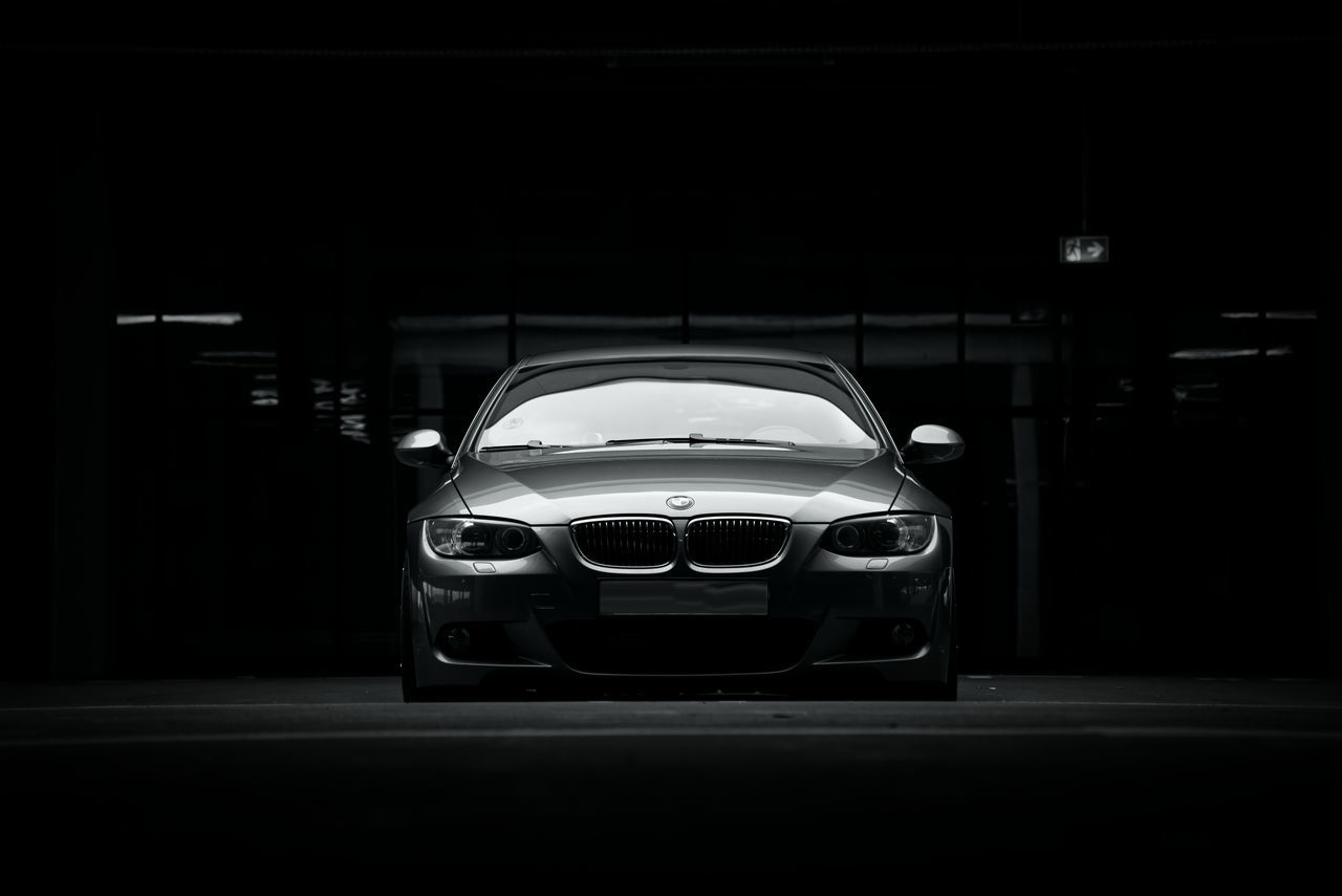 car, vehicle, motor vehicle, mode of transportation, automobile, land vehicle, transportation, luxury vehicle, sports car, wheel, automotive exterior, executive car, indoors, monochrome, black and white, sports sedan, no people, dark, supercar, bumper, night