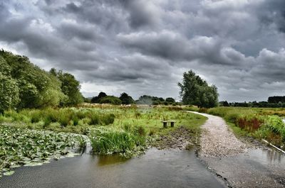 Scenic view of lake against cloudy sky