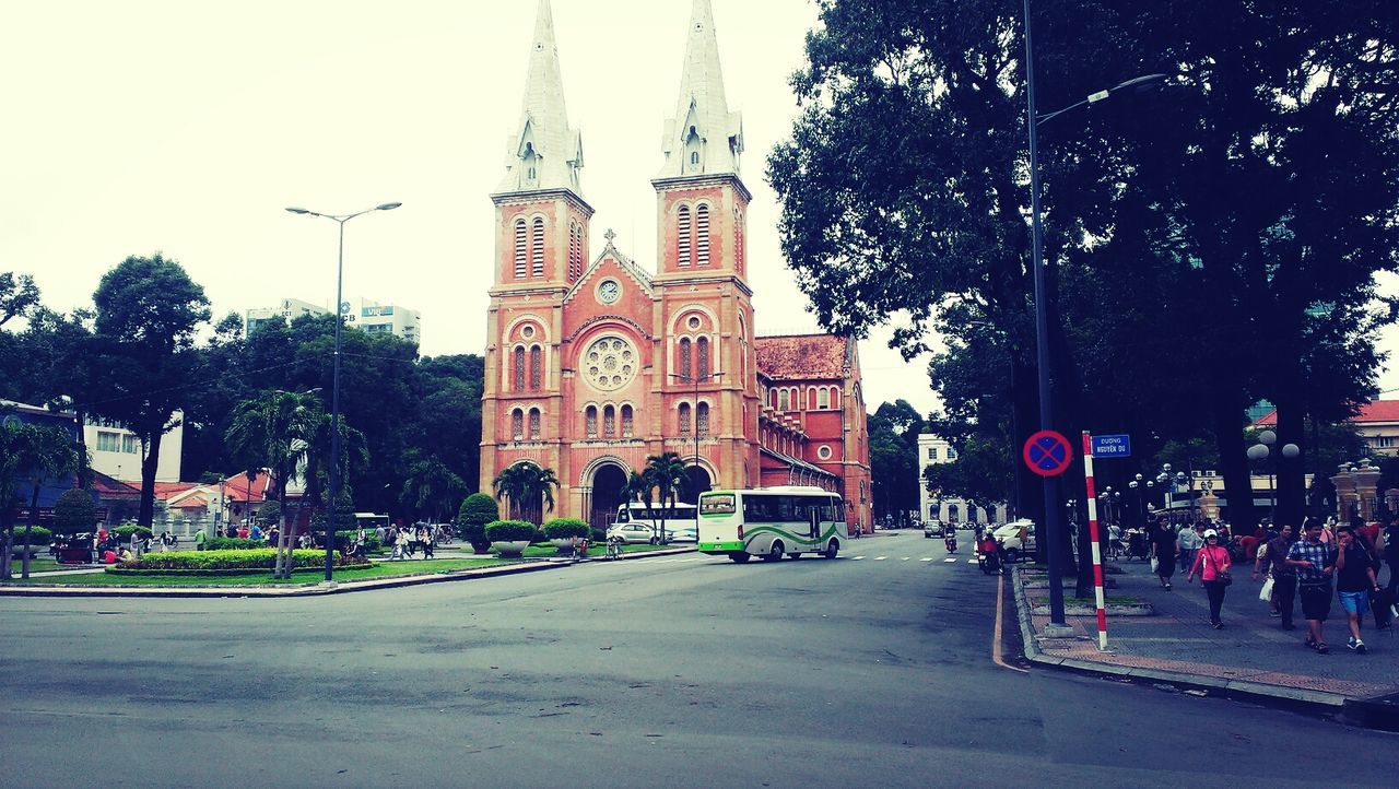 architecture, building exterior, built structure, tree, street, religion, city, place of worship, church, spirituality, incidental people, travel destinations, famous place, road, tower, transportation, clock tower, travel