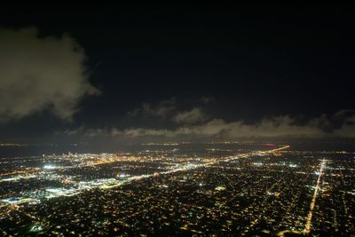 High angle view of illuminated city against sky at night