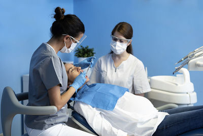 Dentists examining pregnant woman in clinic