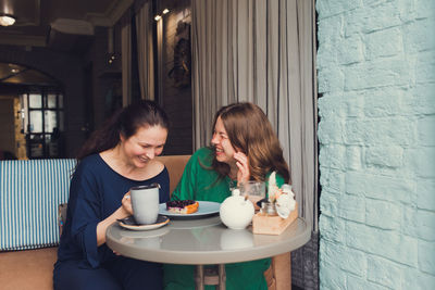 Two women talking and drinking coffee in cafe