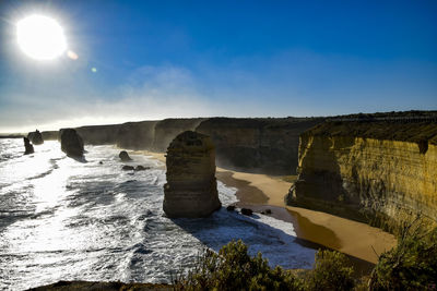 Scenic view of rock formation in sea against blue sky