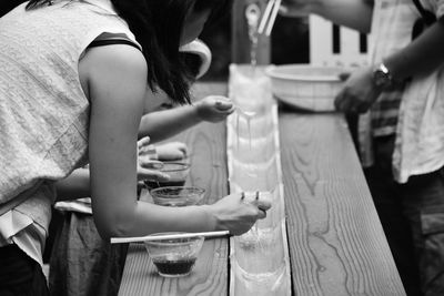 Midsection of people having somen in restaurant