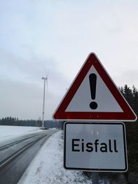 Information sign on road against sky during winter