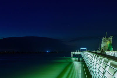 Illuminated city against clear sky at night