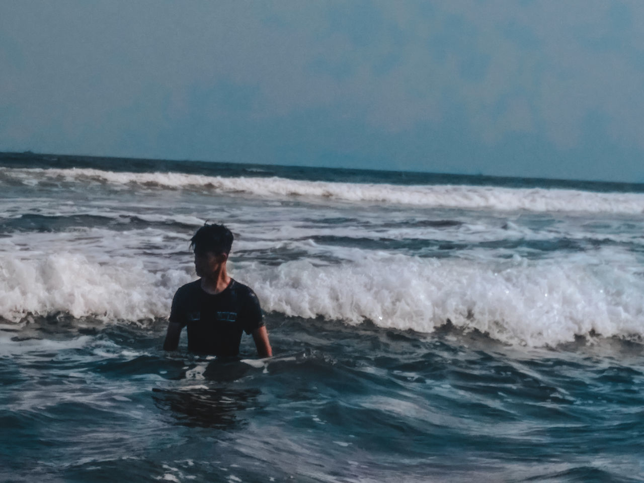 FULL LENGTH OF MAN AT SEA SHORE AGAINST SKY