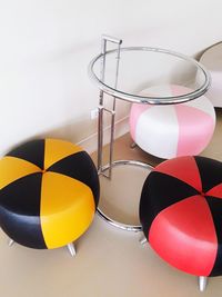 Close-up of multi colored balloons on table against wall at home