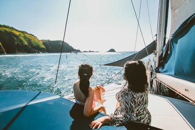 Female friends relaxing on yacht during sunny day