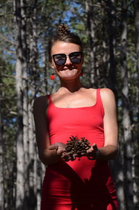 Portrait of beautiful young woman wearing sunglasses standing outdoors